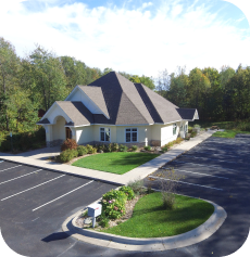 The image of a building with a gray roof and white walls