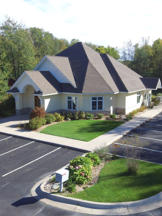 The image of a building with a gray roof and white walls