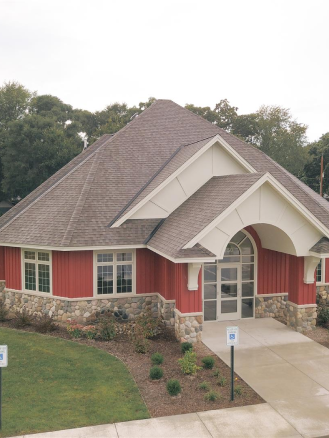 The image of a building with a gray roof and red walls