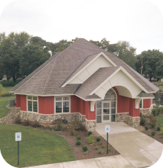 The image of a building with a gray roof and red walls