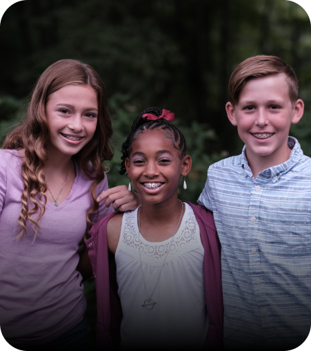 Image of three teenagers, two girls and a boy, smiling