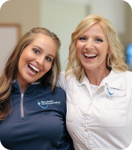 Our Bandeen Orthodontics and Center for Dental Sleep Medicine dentists smiling back to back while crossing their arms